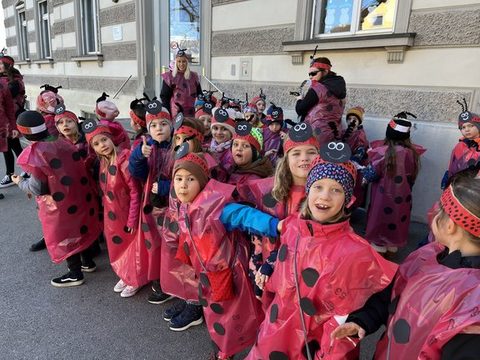 Kinder der Klassen 1a, 1b und 1c als Marienkäfer verkleidet unterwegs beim Faschingsumzug